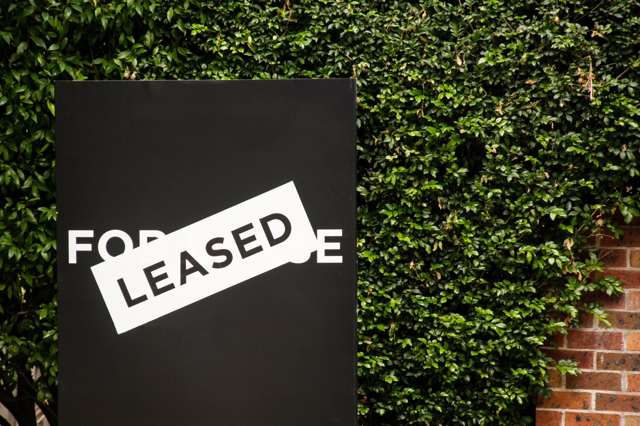 For,lease,and,leased,sign,on,a,black,display,outside
